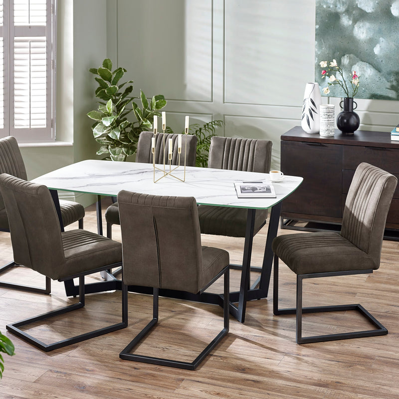 Dining room with a round table and gray chairs on a wooden floor.