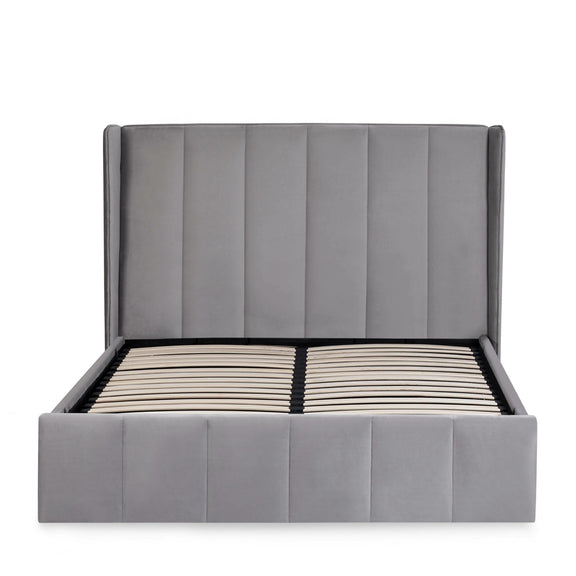 Gray upholstered bed with striped mattress on a white background