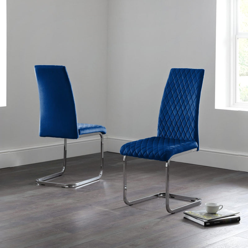 Two blue chairs with quilted design on a gray floor and light gray walls.