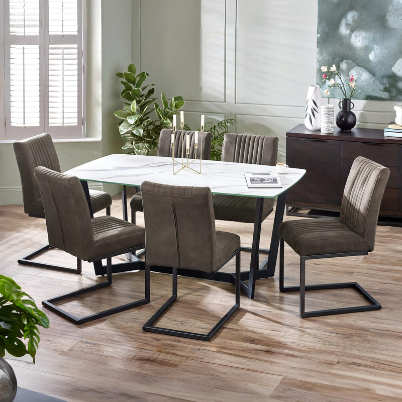 Dining room with a marble table and brown chairs on a wooden floor.