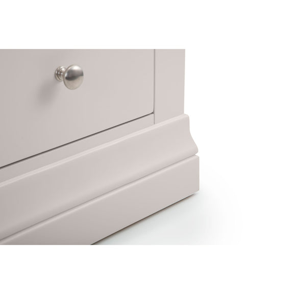 Close-up of a light gray dresser with a silver knob on a white background