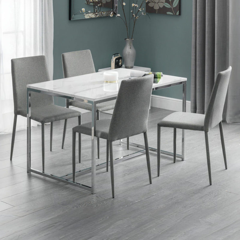 Dining room with a rectangular table and four gray chairs against a teal wall.