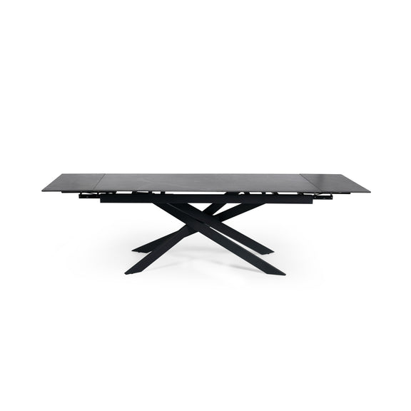 Modern dining table with black glass top and metal base on a white background