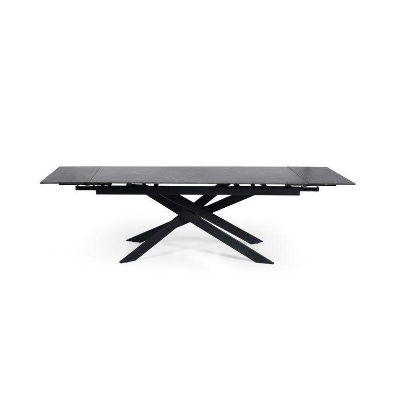Modern dining table with black glass top and metal base on a white background