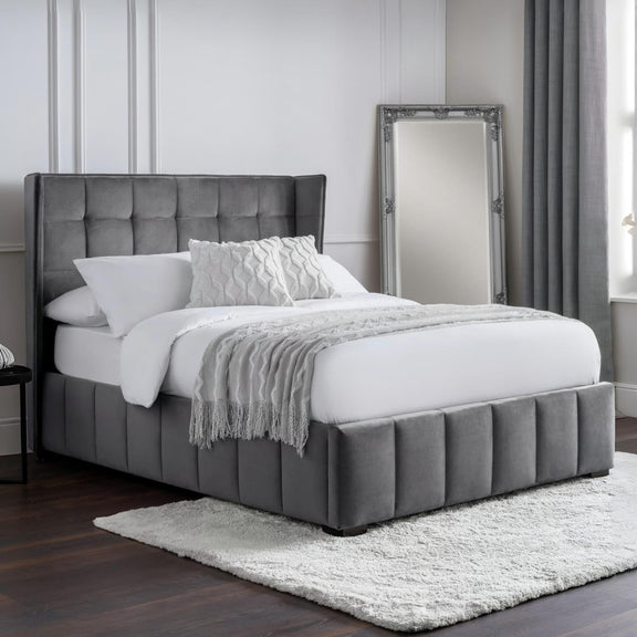 Gray upholstered bed with white bedding in a bedroom setting
