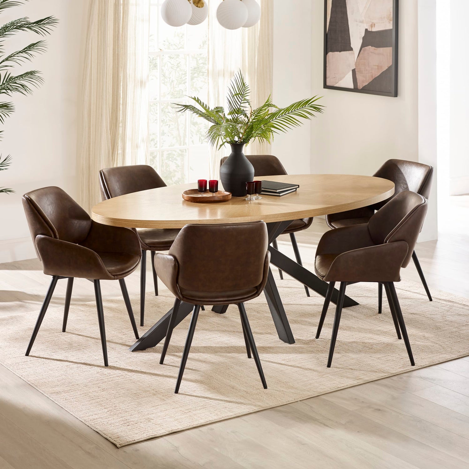 Dining room with a round wooden table and six brown chairs on a light wood floor.