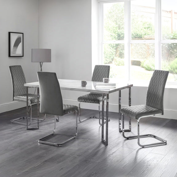 Dining room with a table and four chairs in a modern interior setting.