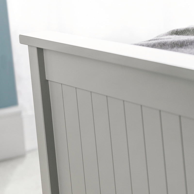 Close-up of a gray wooden bed frame with a white mattress.