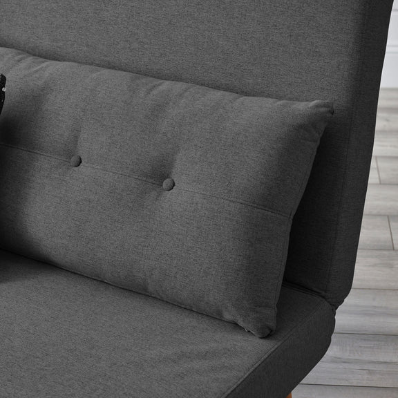 Gray upholstered headboard with tufted design on a wooden floor.