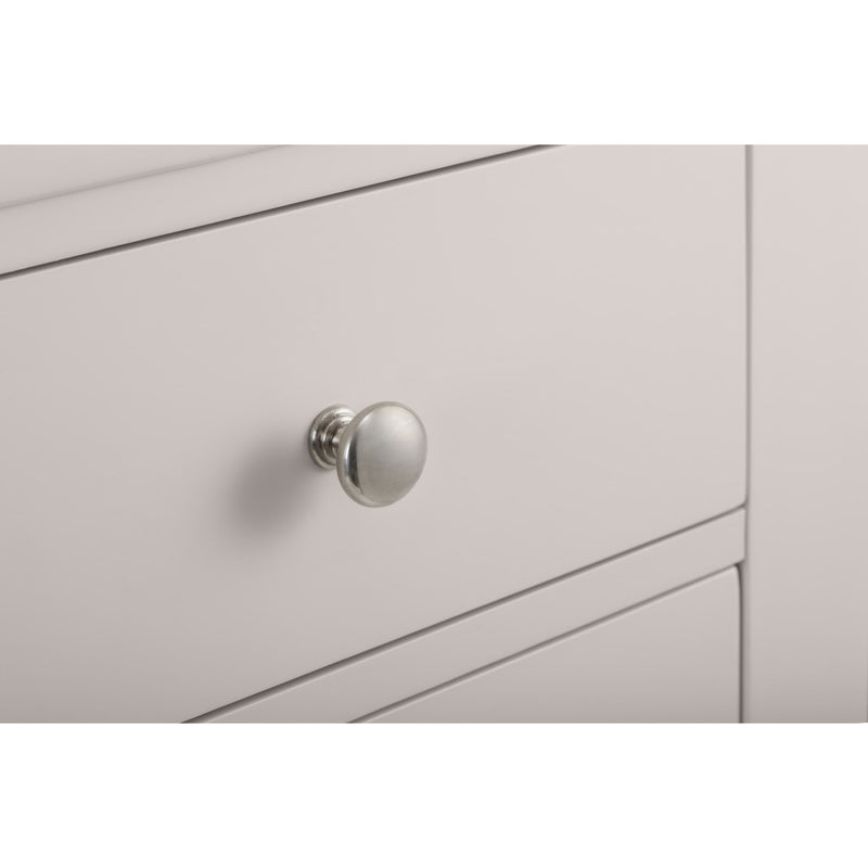 Close-up of a light gray cabinet with a silver knob on a white background