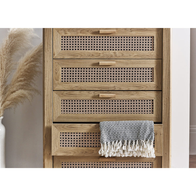 Wooden cabinet with woven design and a towel draped over it, with pampas grass on the side.