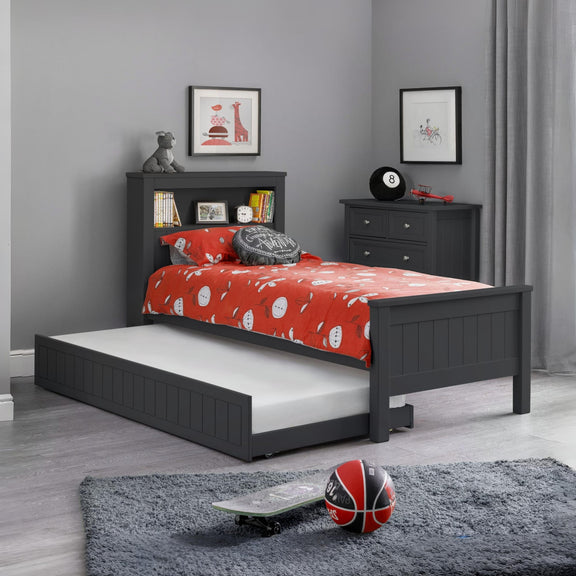 Children's bedroom with a black bed frame, red bedding, and toys on a gray rug.