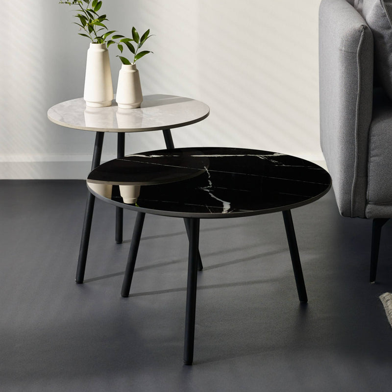 Two round marble coffee tables with black and white marbled surfaces in a living room setting.
