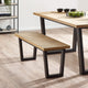 Wooden dining table and bench set on a wooden floor with a white wall background.