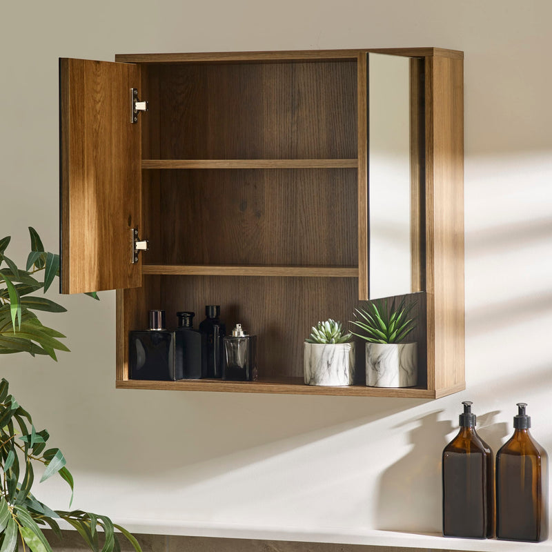 Wooden medicine cabinet with open door displaying bottles and plants, on a neutral wall.