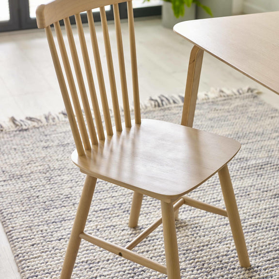 Wooden chair in a room with a rug and table