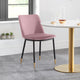 Pink chair with black legs in front of a white table with gold legs in a room.
