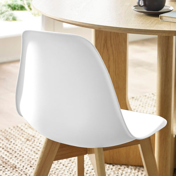 White chair in front of a wooden table with a blurred background