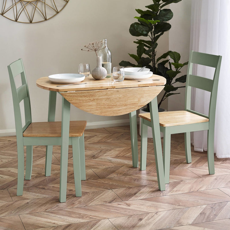Dining table with chairs in a room with a plant and decorative wall piece.