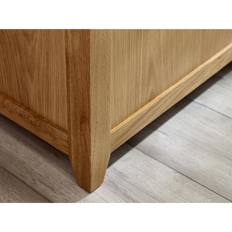 Close-up of a wooden furniture leg on a light wood floor.