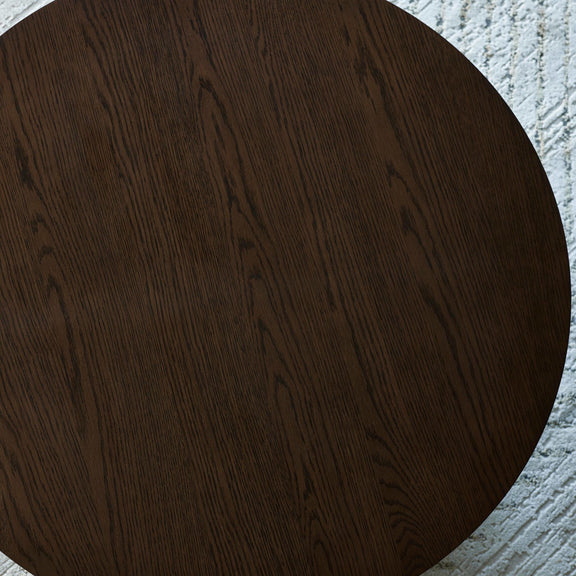 Dark wooden circular table on a textured gray surface