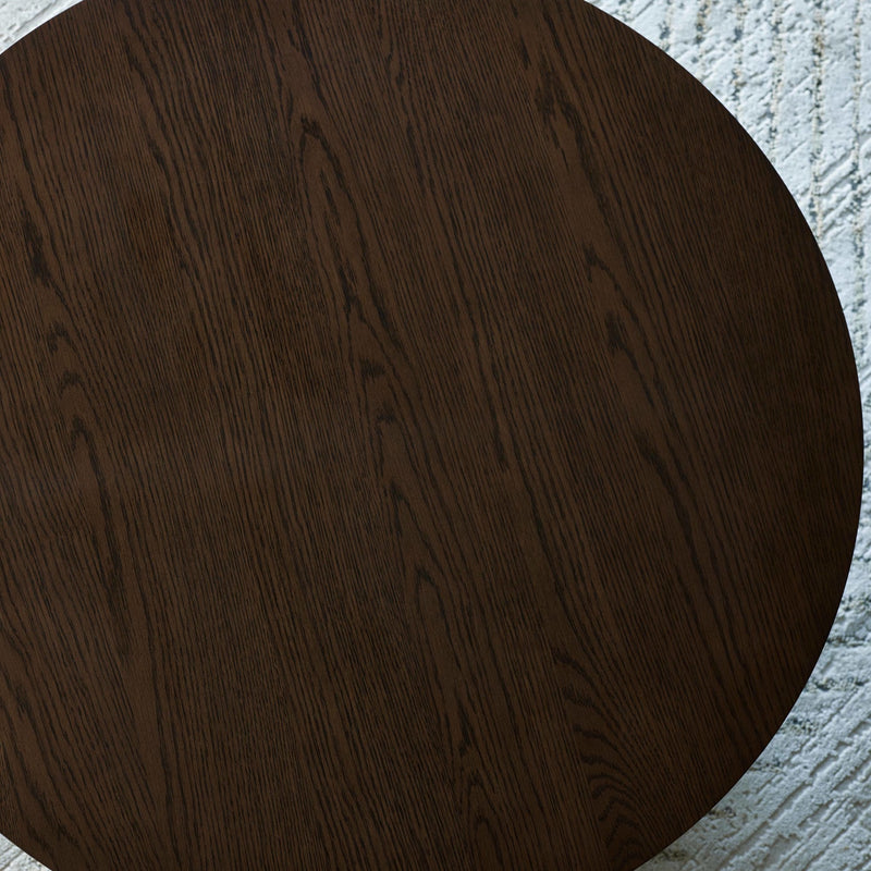 Dark wooden circular table on a textured gray surface