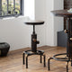 Two round tables with industrial design on a wooden floor.