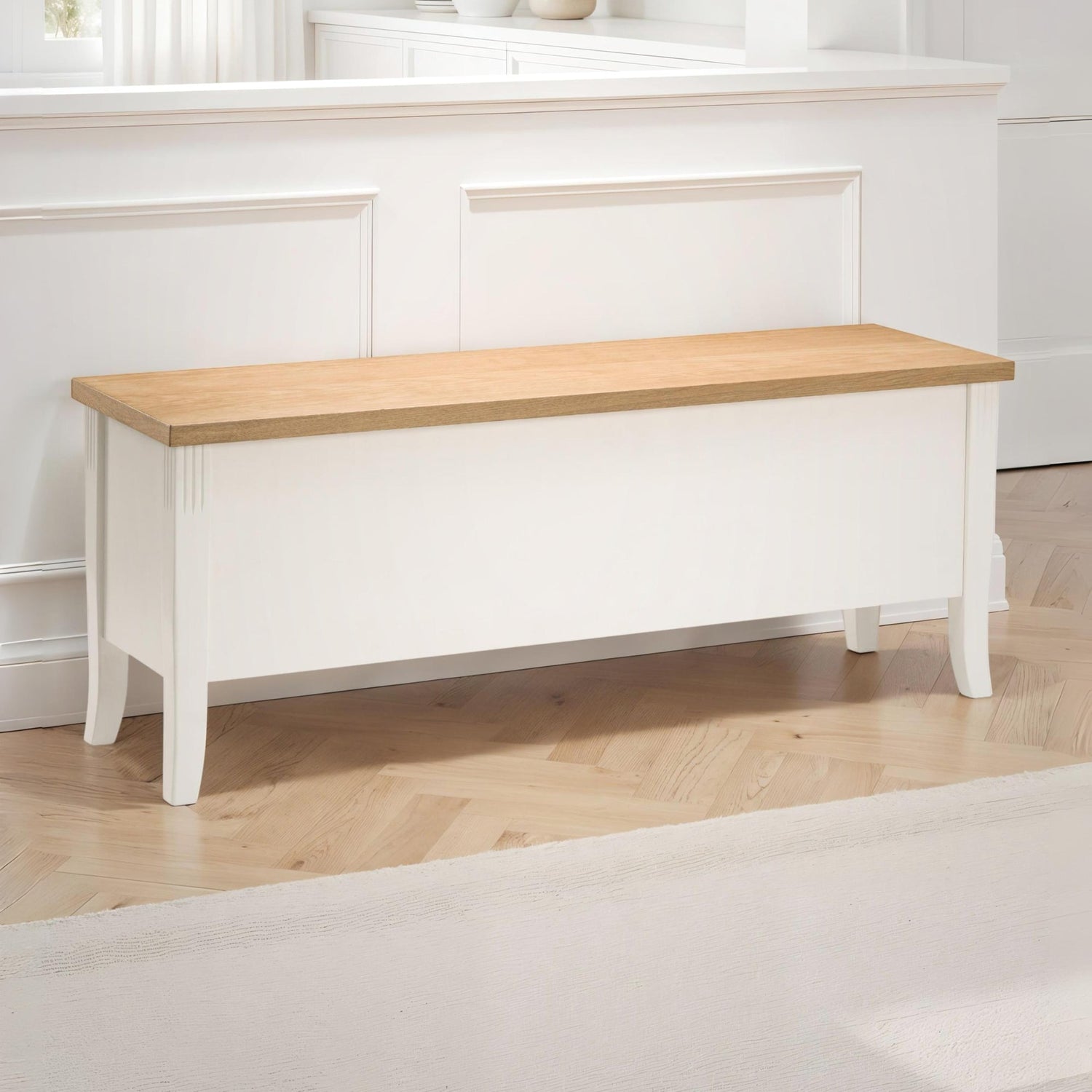 Wooden bench with white base against a white wall