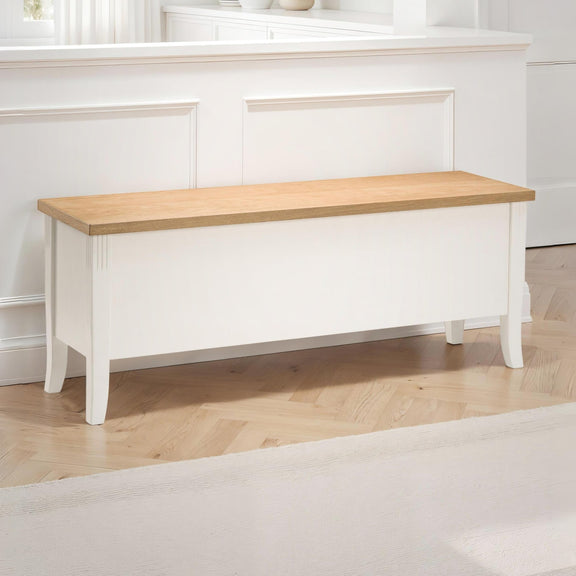 Wooden bench with white base against a white wall