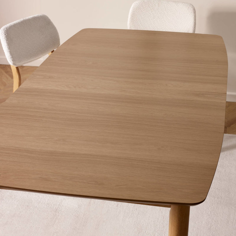 Wooden dining table with chairs in a neutral setting