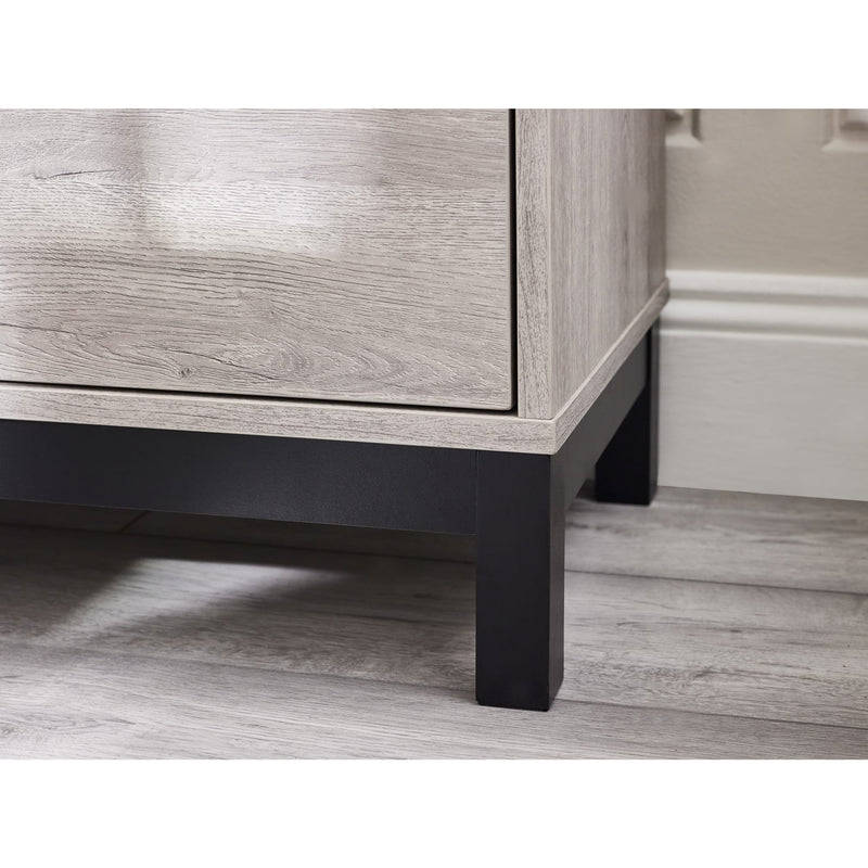 Wooden cabinet with a black base on a wooden floor