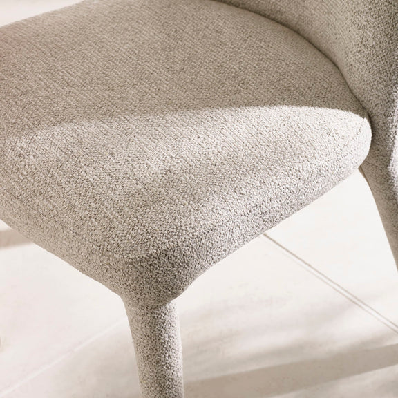 Close-up of a textured beige armchair on a light background