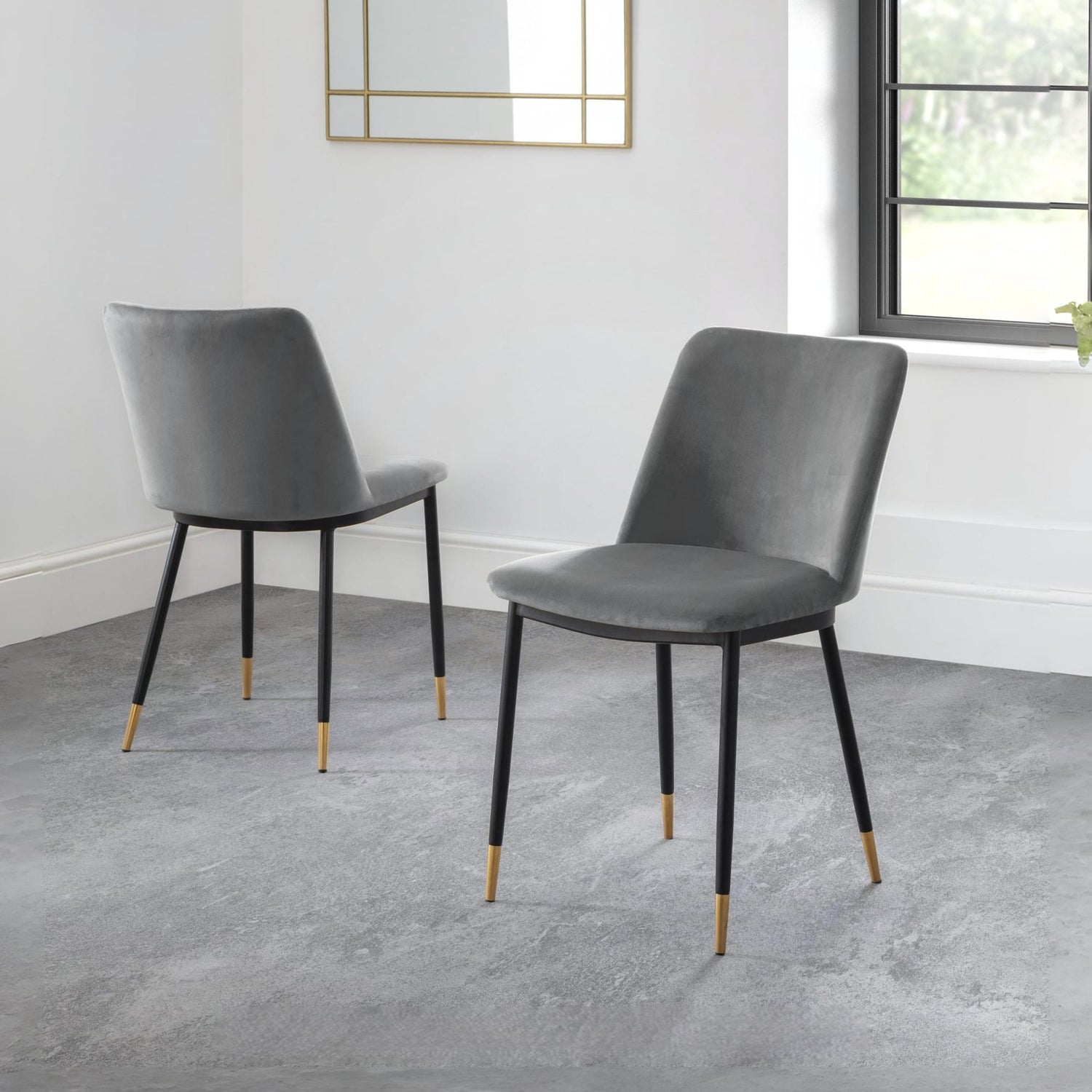 Two gray chairs with black legs on a gray floor.
