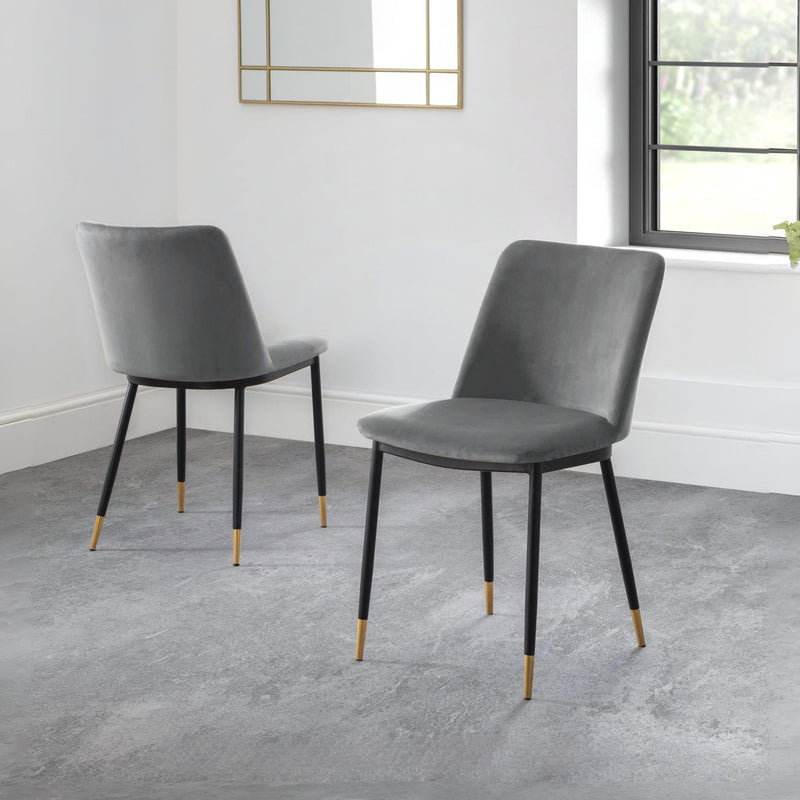 Two gray chairs with black legs on a gray floor.