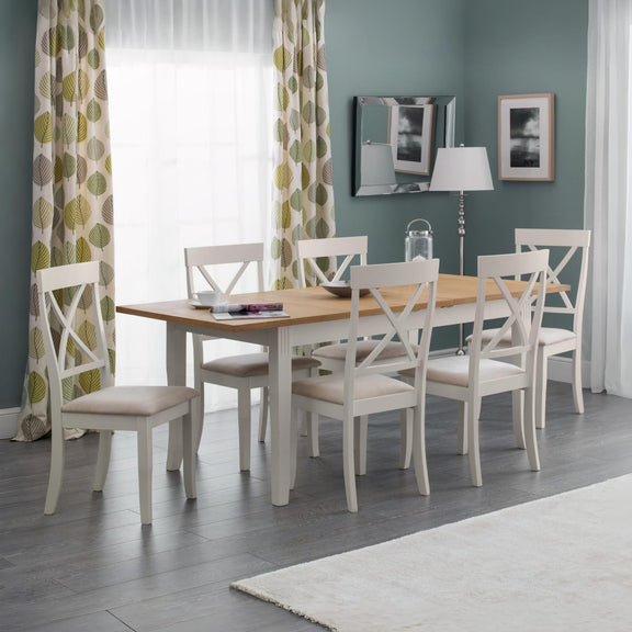 Dining room with a wooden table and white chairs against a gray wall with decorative elements.