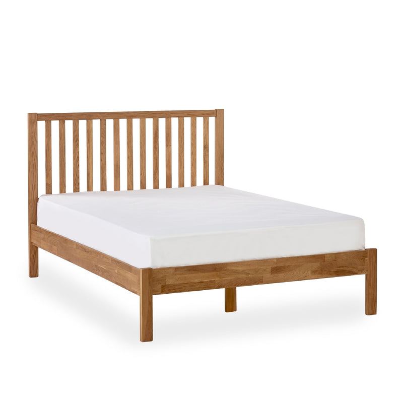 Wooden bed frame with white mattress on a white background