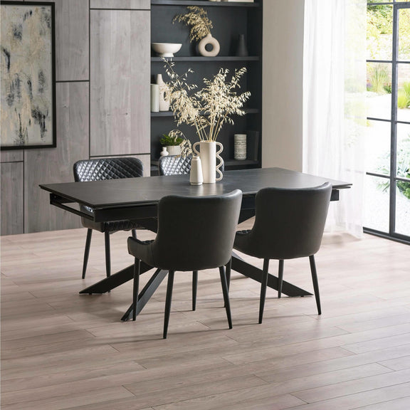 Dining room with a black dining table and chairs in a modern interior setting.