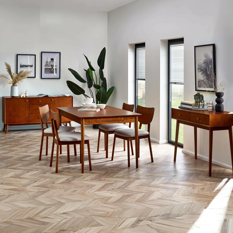 Dining room with wooden furniture, including a table and chairs, on a herringbone wood floor.