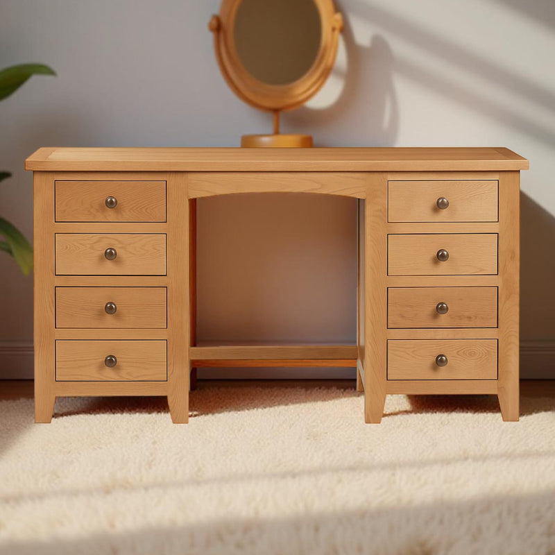 Wooden vanity with multiple drawers and a mirror on a light background
