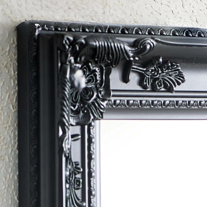 Decorative black frame with intricate details on a light gray wall.