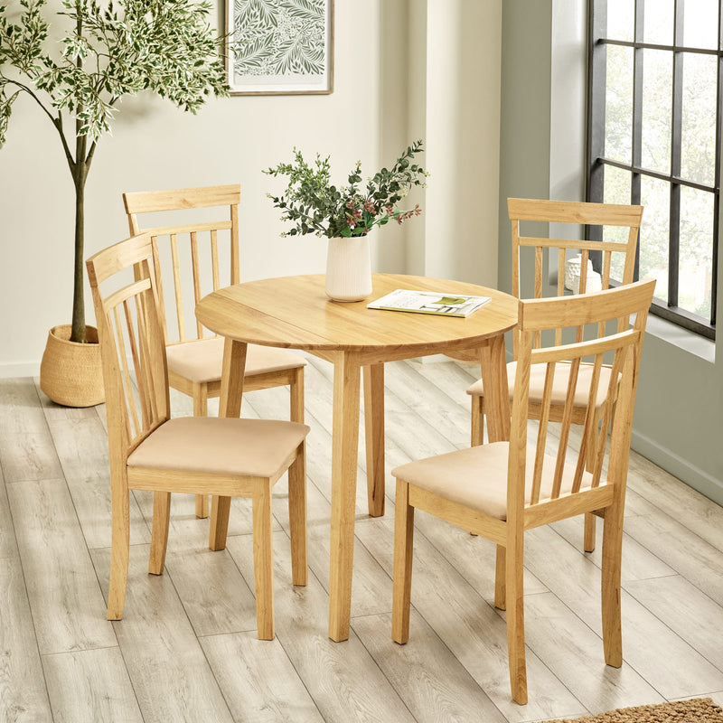 Wooden dining set with table and chairs in a room with plants and a window.