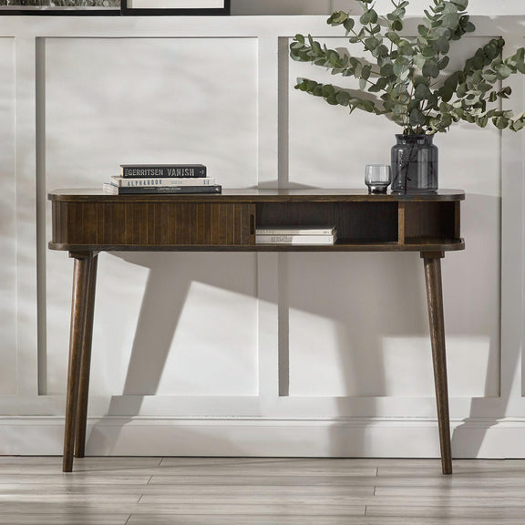 Wooden desk with books and a plant in a modern interior setting