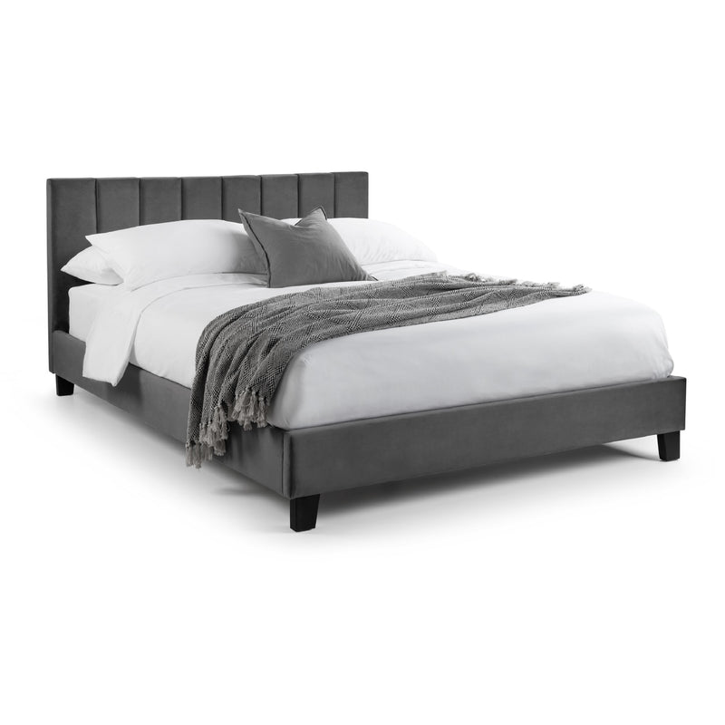Gray upholstered bed with white bedding and gray blanket on a white background