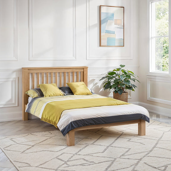 Wooden bed with yellow bedding in a bright bedroom