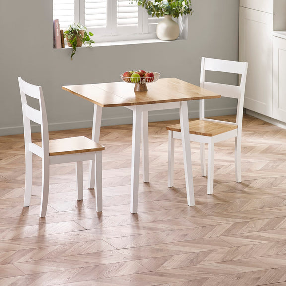 Dining table with two chairs in a room with a window and plants.