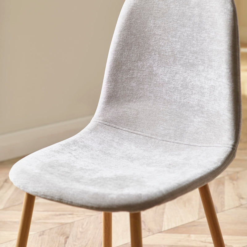 Gray upholstered chair with wooden legs on a wooden floor.