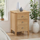 Wooden nightstand with three drawers in a room with plants and a window.