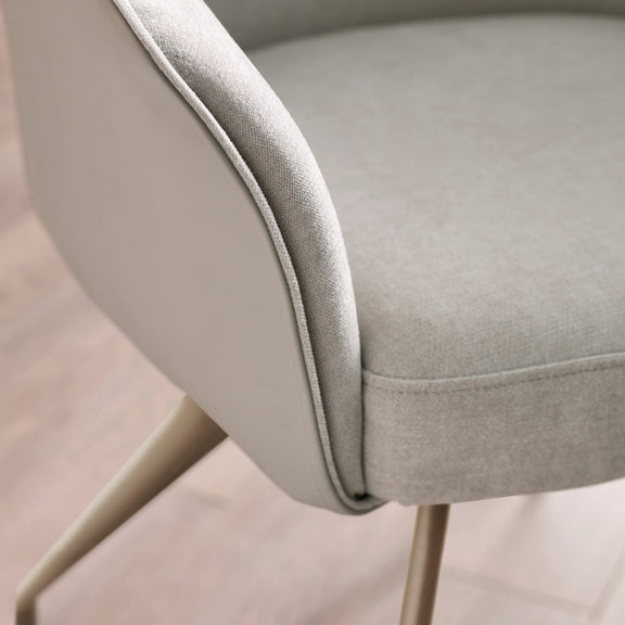 Close-up of a gray upholstered chair with a blurred background