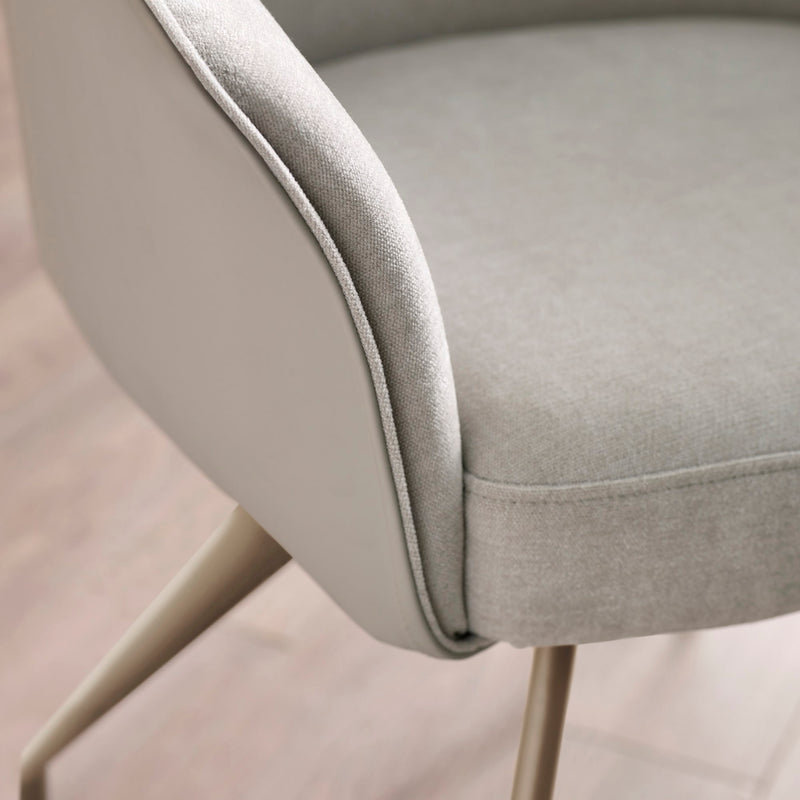 Close-up of a gray upholstered chair with a blurred background