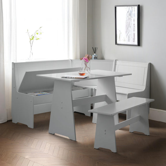 White dining table with benches in a room with a window and framed picture on the wall.